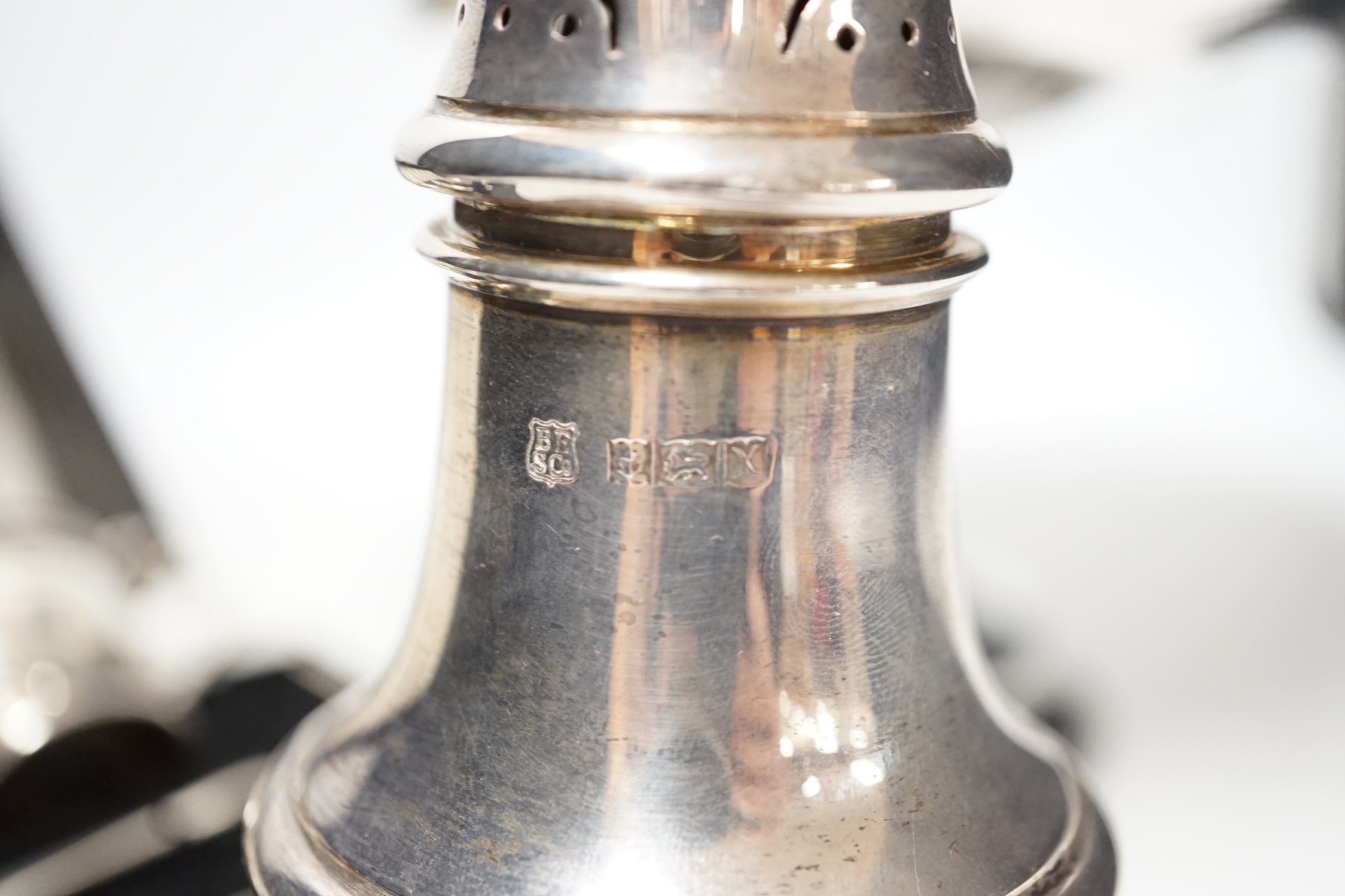 A modern silver baluster sugar caster, Birmingham, 1972, 17.5cm, a cased silver three piece condiment set an a George V silver tazza, weighted.